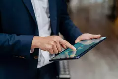 Image of an businessman checking stock market chart on digital tablet. Fund manager looking at stock market chart on digital tablet.